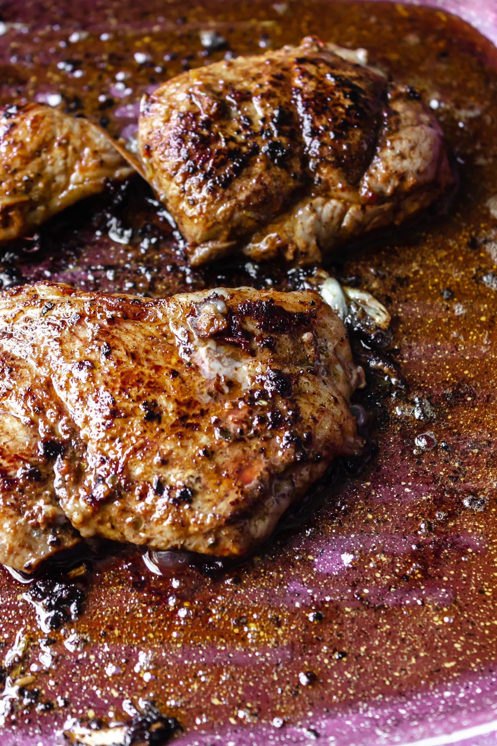 adobo sauce marinated steaks cooking in a large skillet
