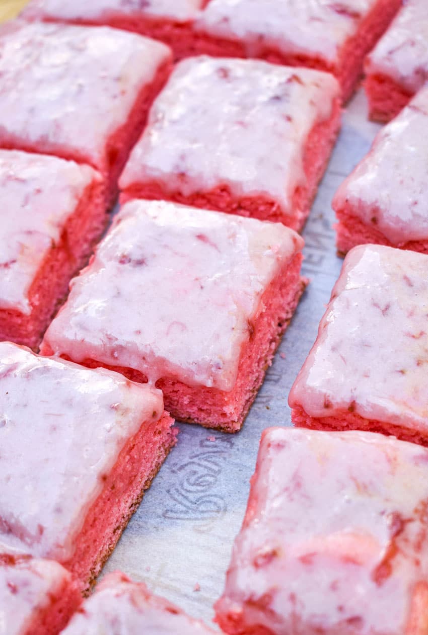 sliced strawberry brownies on a sheet of white parchment paper