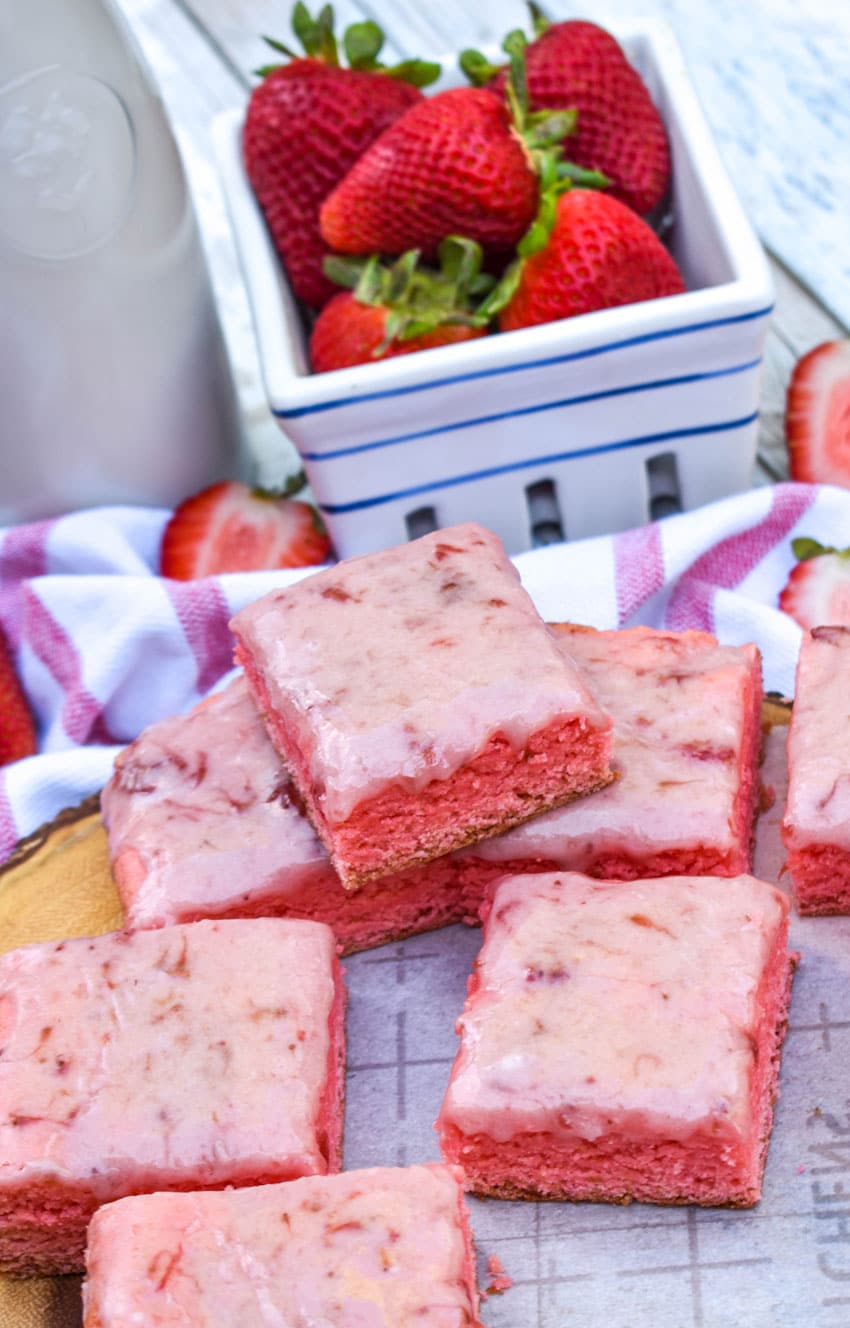 a pile of strawberry brownies on white parchment paper
