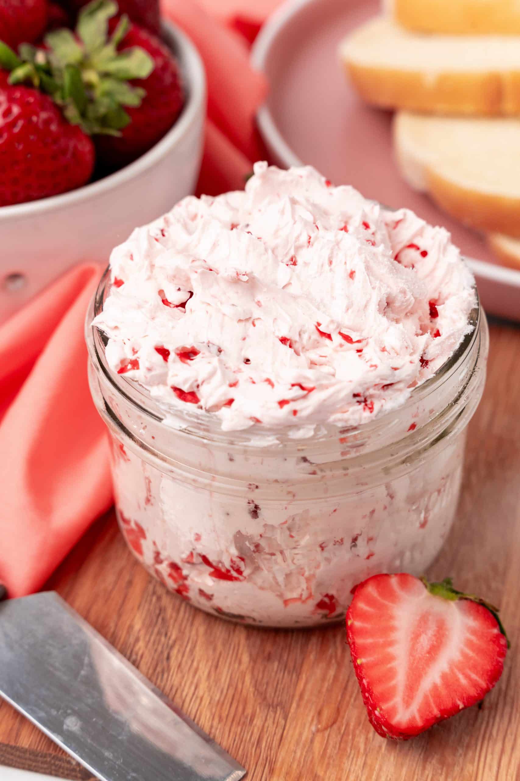 homemade strawberry butter recipe in a small glass jar on a wooden cutting board
