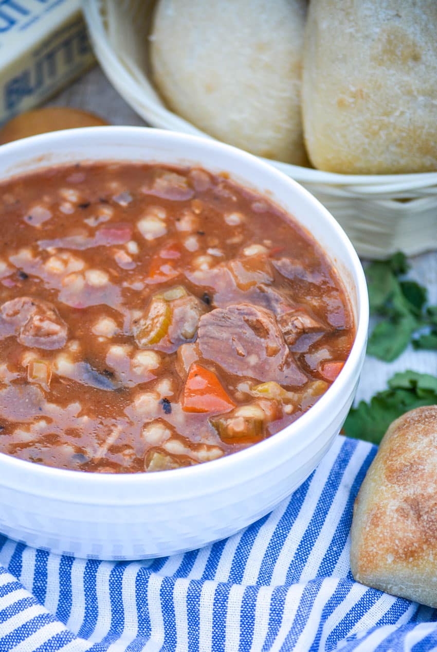 slow cooker beef and barley soup in a white bowl