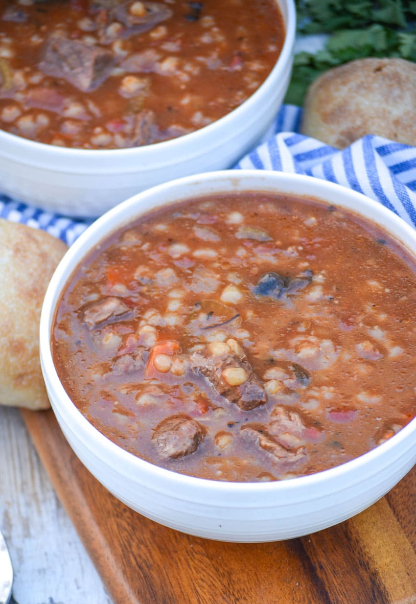 slow cooker beef and barley soup in a white bowl