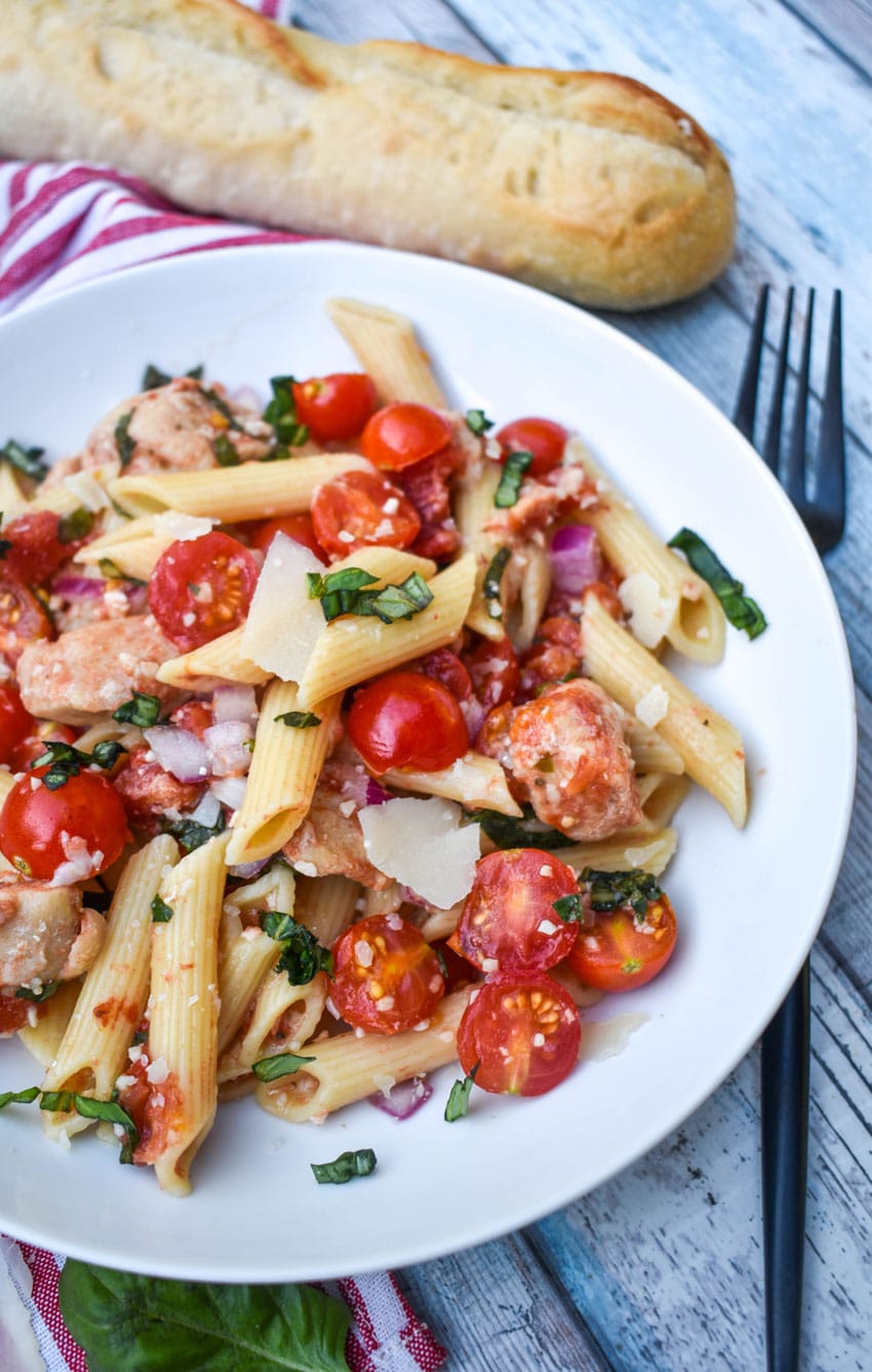 bruschetta chicken and pasta on a white plate