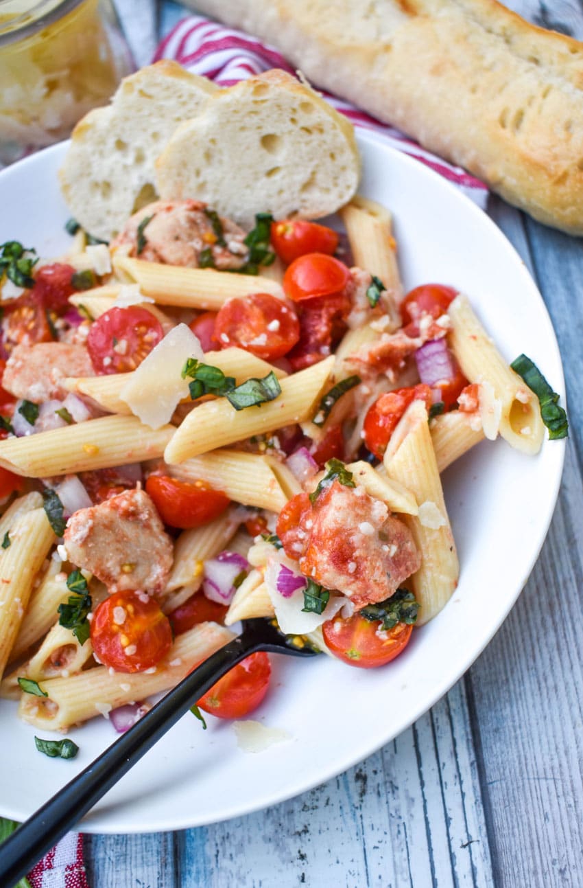 bruschetta chicken and pasta on a white plate