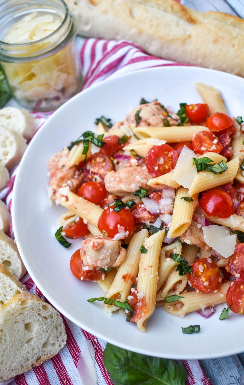 bruschetta chicken and pasta on a white plate