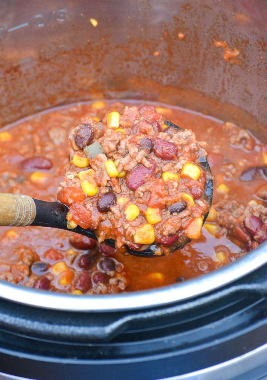 a serving spoon scooping taco chili out of an instant pot