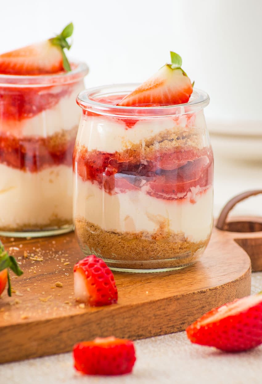strawberry cheesecake cups on a wooden cutting board