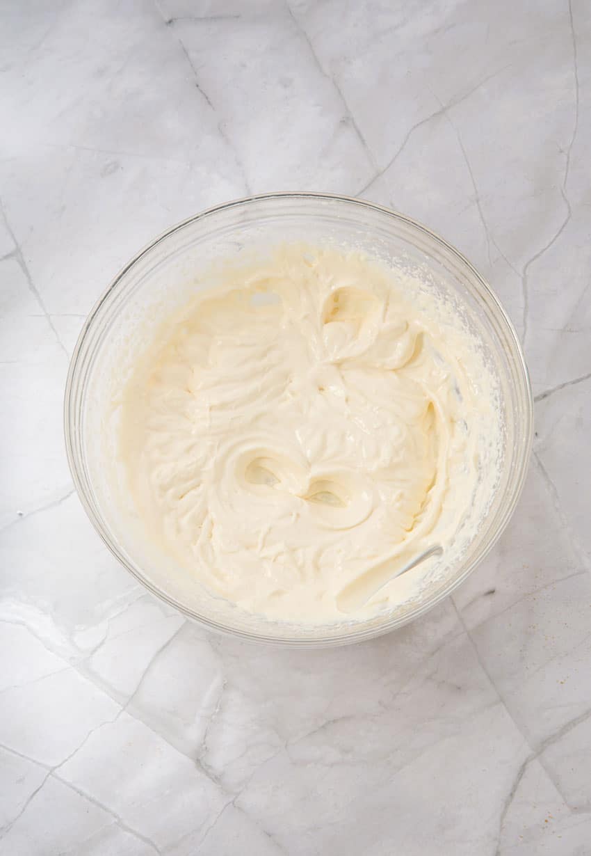 homemade cheesecake filling in a glass mixing bowl