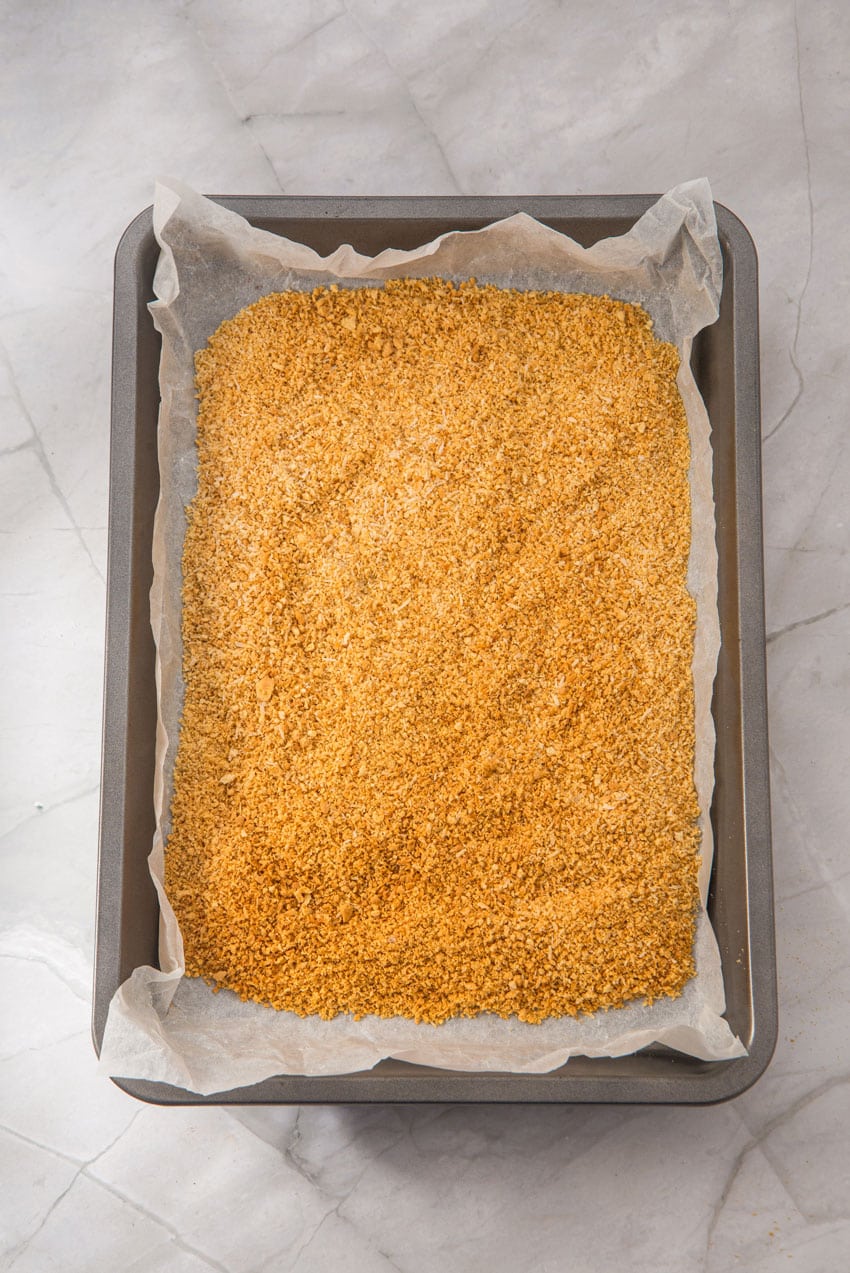 toasted graham cracker crumbs on a parchment paper lined baking sheet