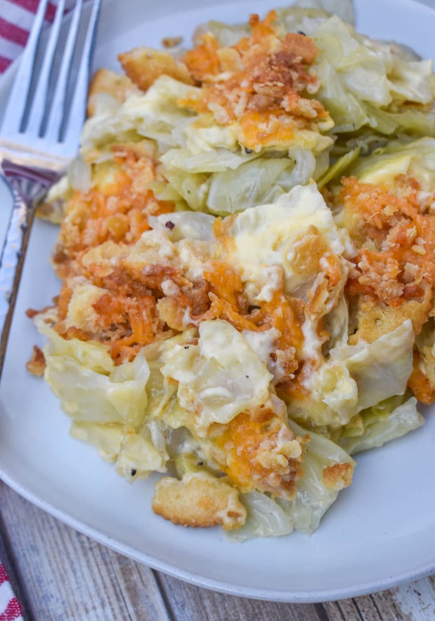 southern cabbage casserole on a white plate with a silver fork on the side