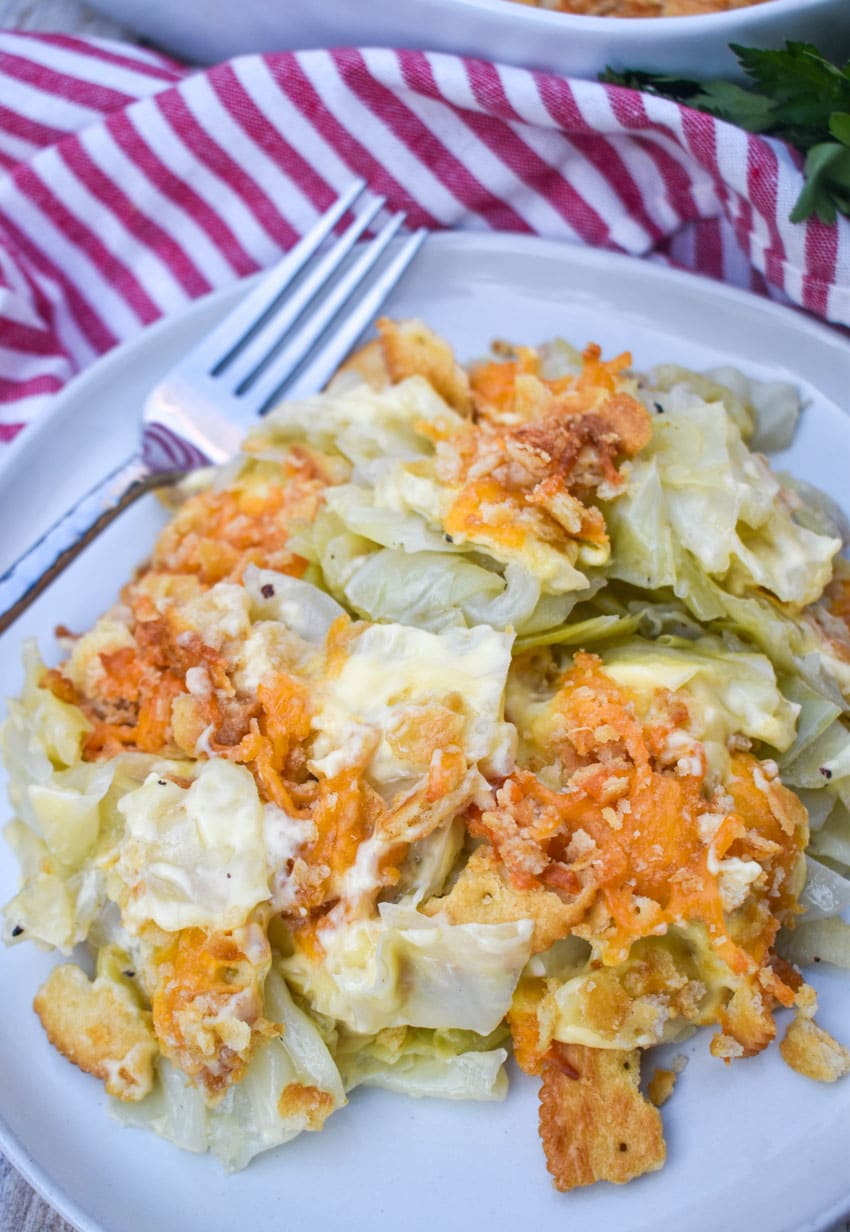 southern cabbage casserole on a white plate with a silver fork on the side