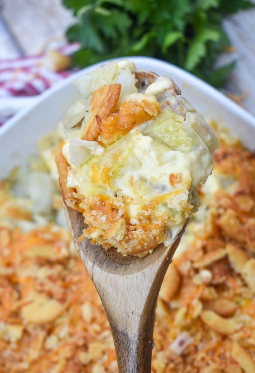 a wooden spoon holding up a scoop of old fashioned cabbage casserole