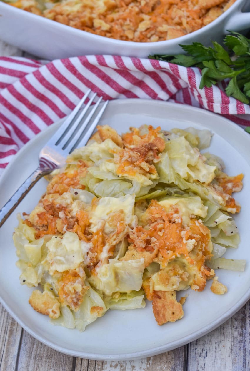 southern cabbage casserole on a white plate with a silver fork on the side