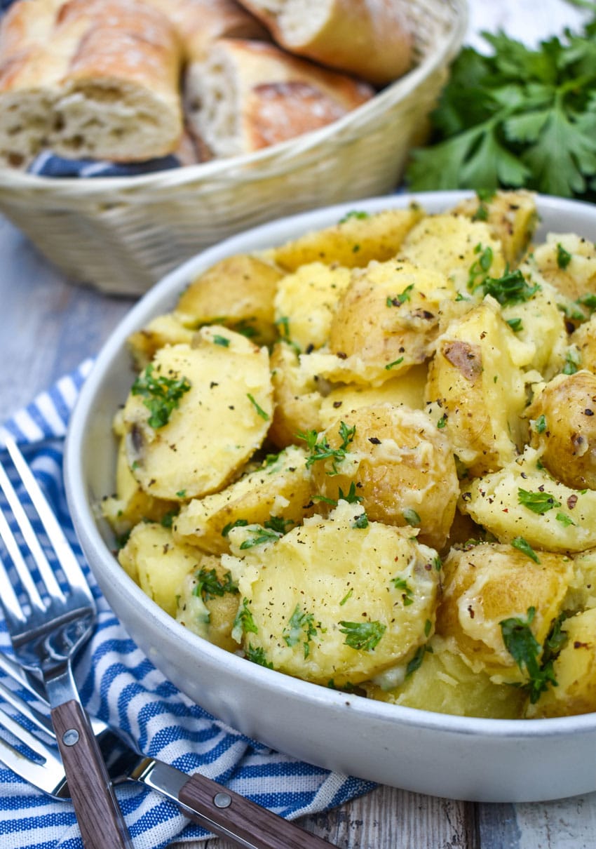 butter and parsley potatoes in a gray serving bowl