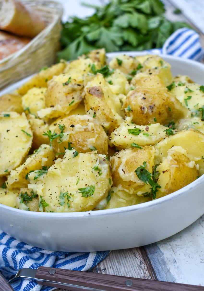 butter and parsley potatoes in a gray serving bowl