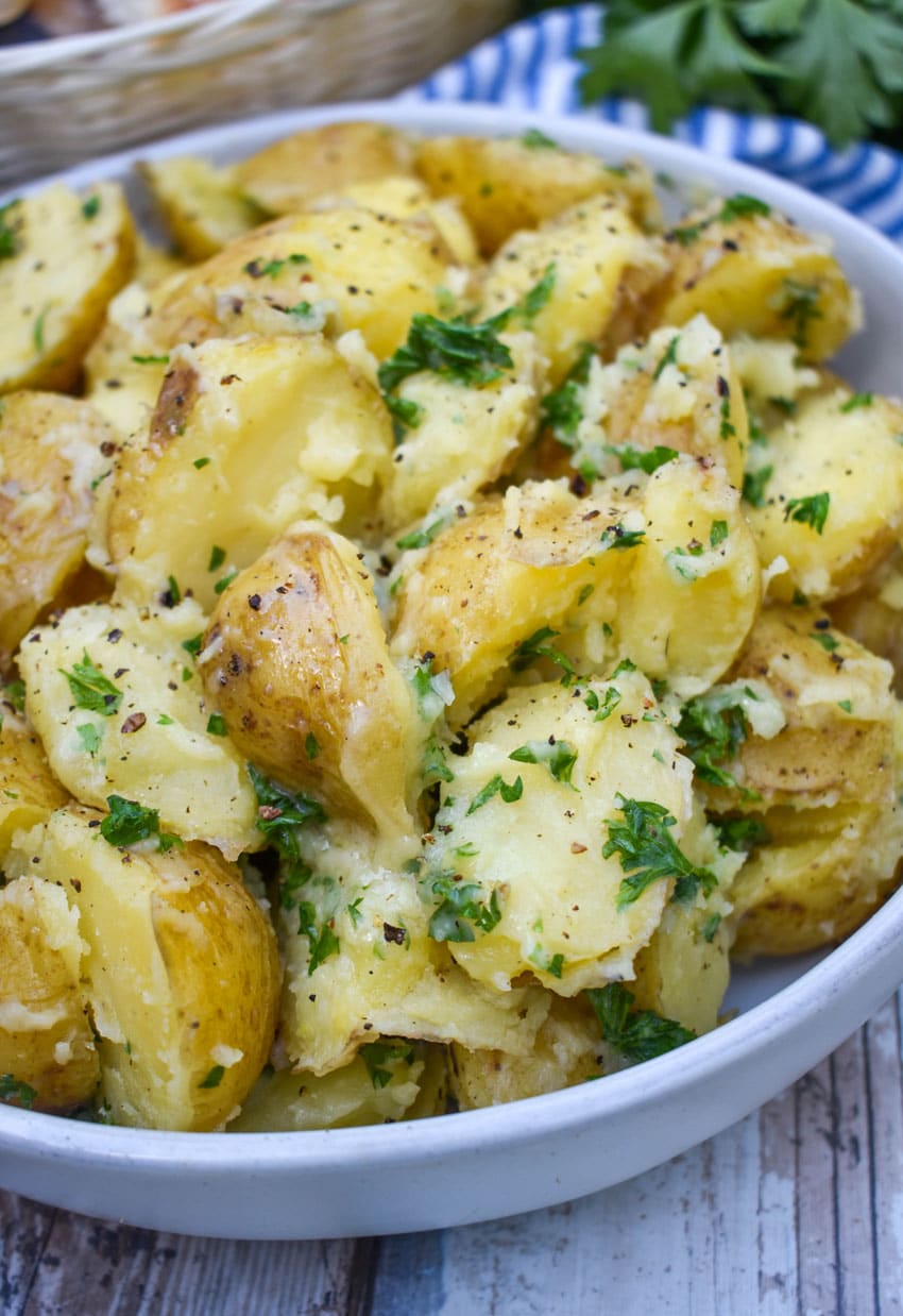 butter and parsley potatoes in a gray serving bowl