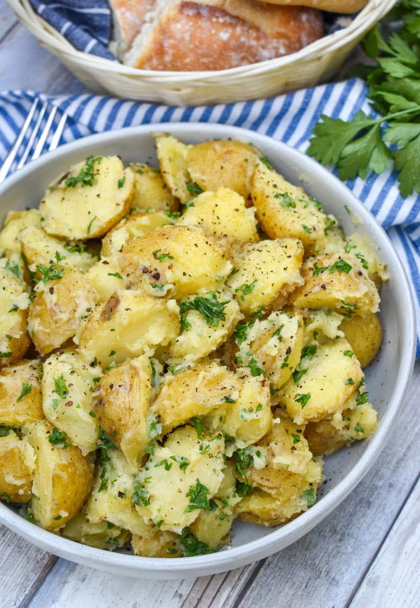 butter and parsley potatoes in a gray serving bowl