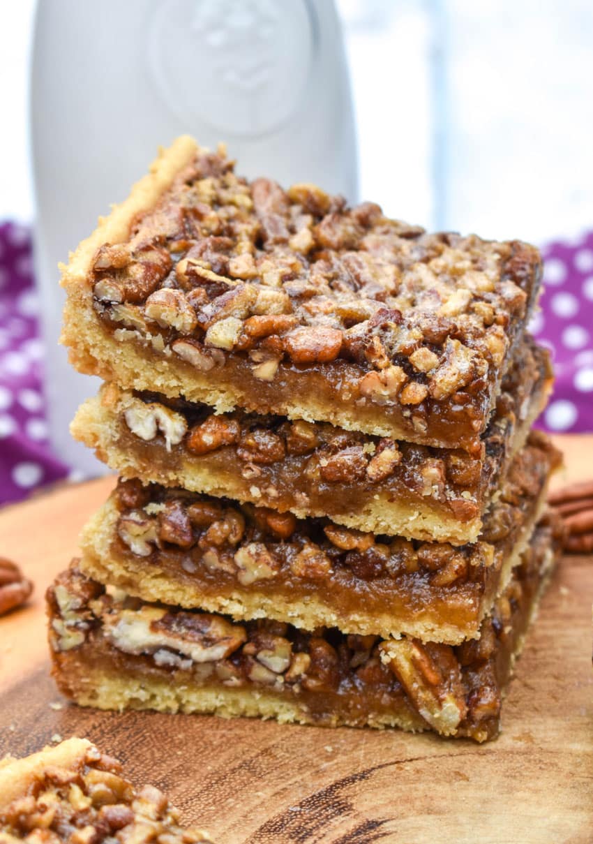 a stack of easy pecan bars on a wooden cutting board