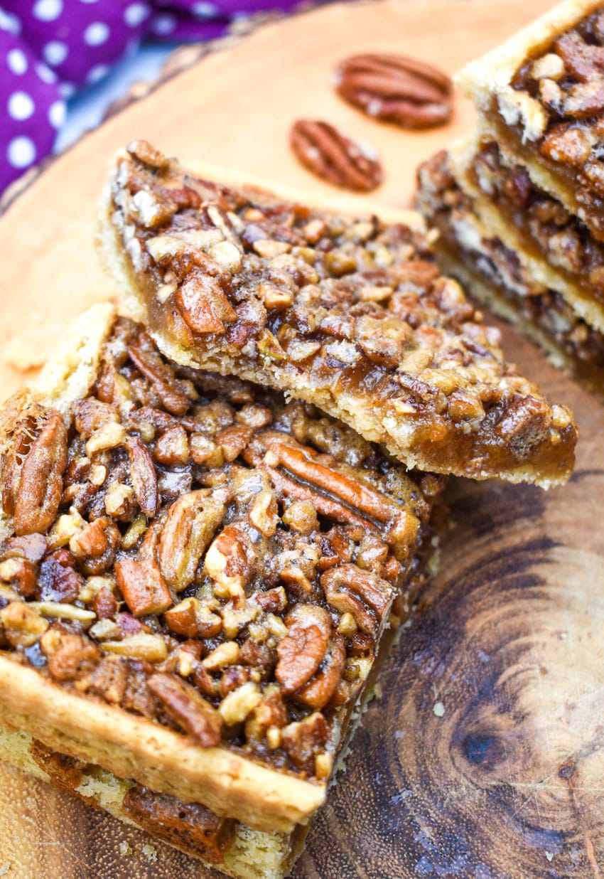 a stack of easy pecan bars on a wooden cutting board