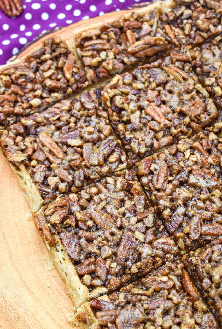 sliced homemade pecan pie bars on a wooden cutting board