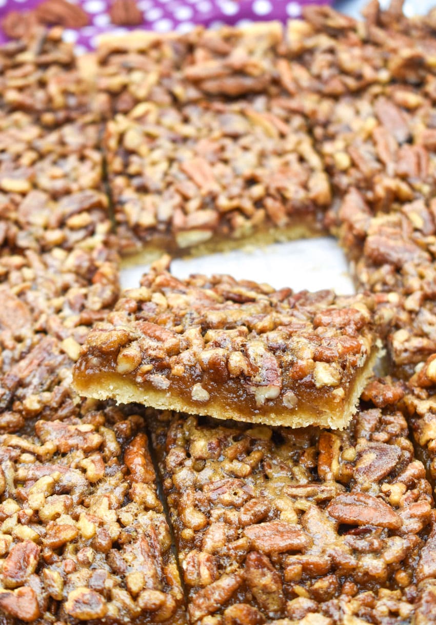 sliced homemade pecan pie bars on a wooden cutting board