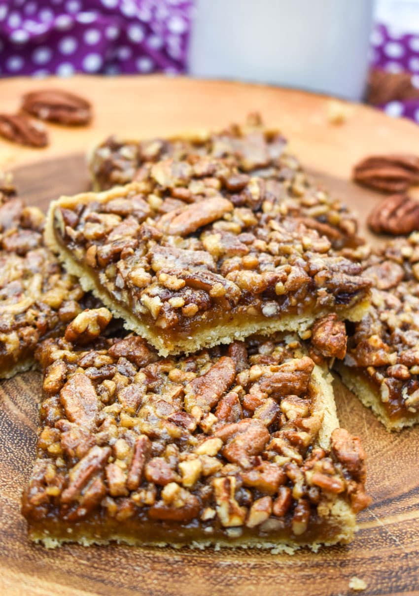 a stack of easy pecan bars on a wooden cutting board