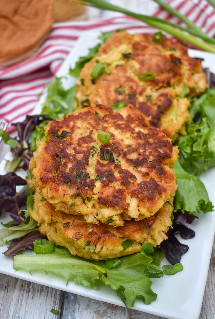 easy tuna patties arranged over a row on a bed of lettuce on a white serving platter