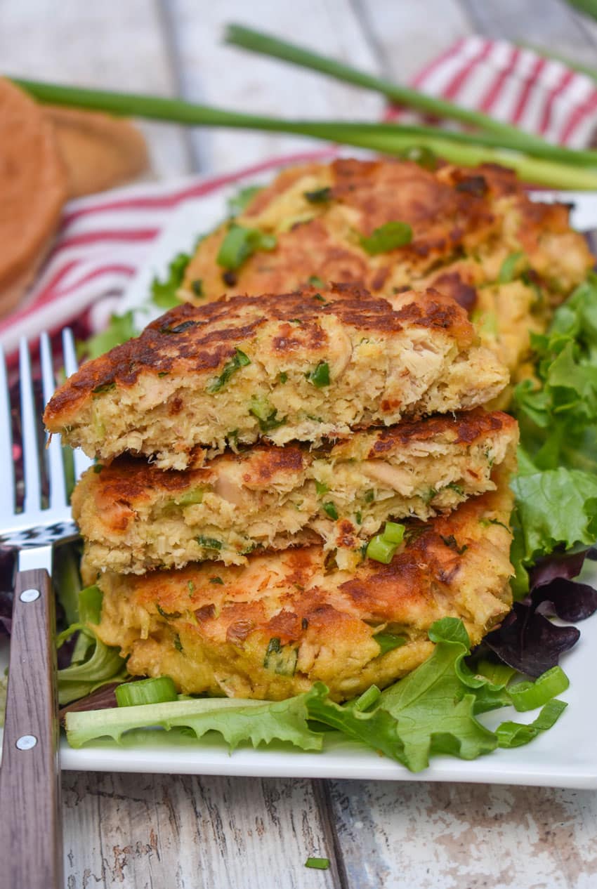 easy tuna patties arranged over a row on a bed of lettuce on a white serving platter