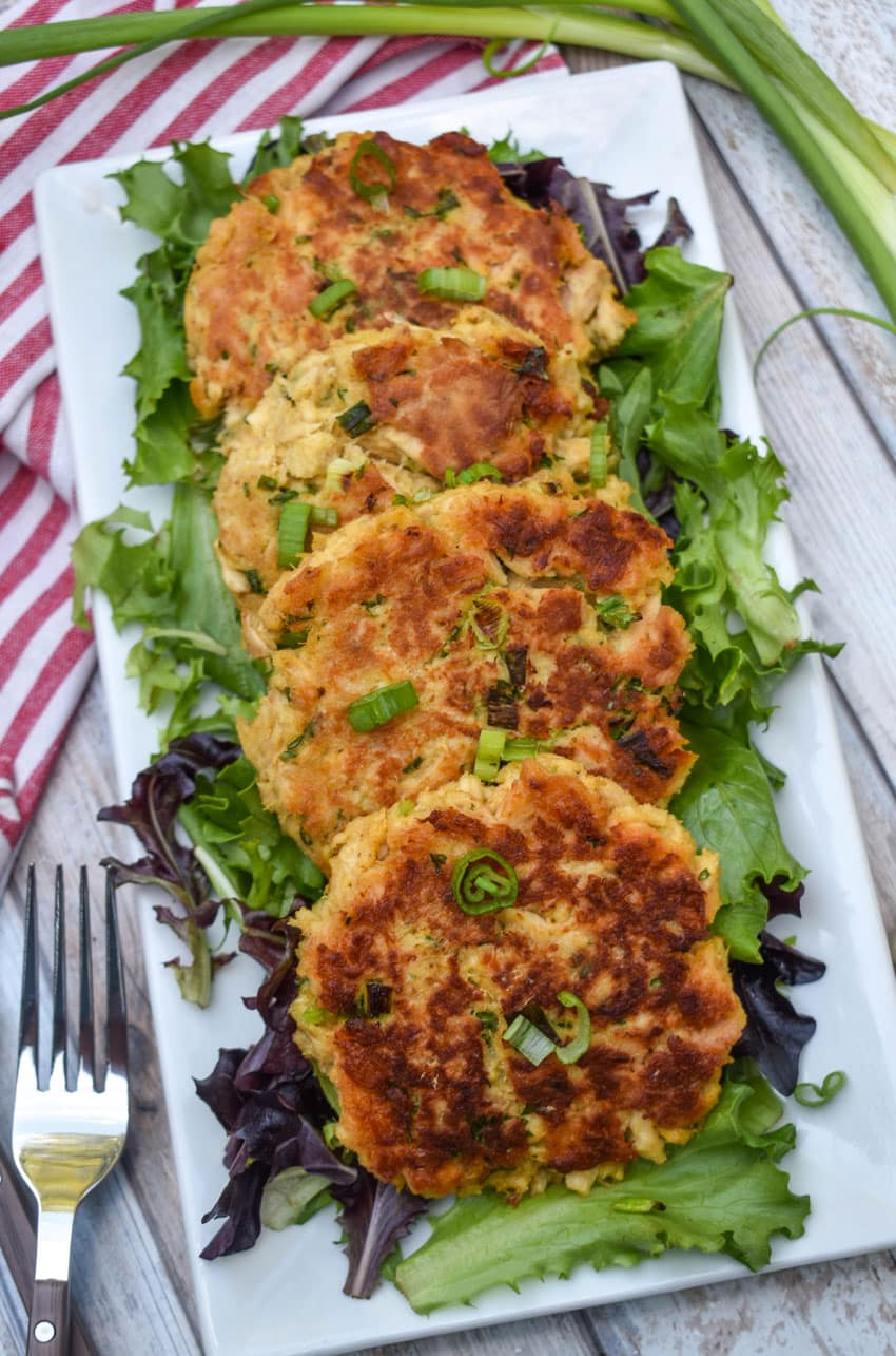 easy tuna patties arranged over a row on a bed of lettuce on a white serving platter