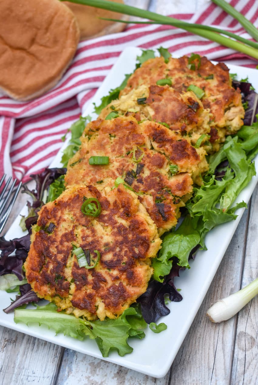 easy tuna patties arranged over a row on a bed of lettuce on a white serving platter