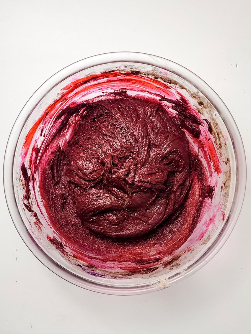 red velvet cookie batter in a glass mixing bowl