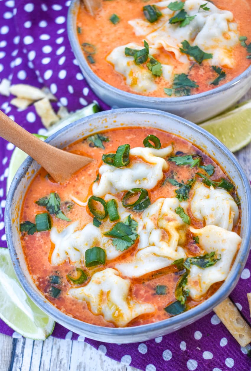 coconut curry soup with wontons in two small gray bowls