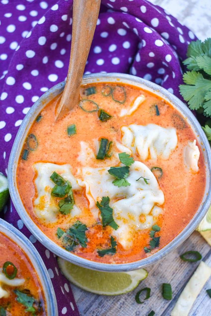 coconut curry soup with wontons in two small gray bowls