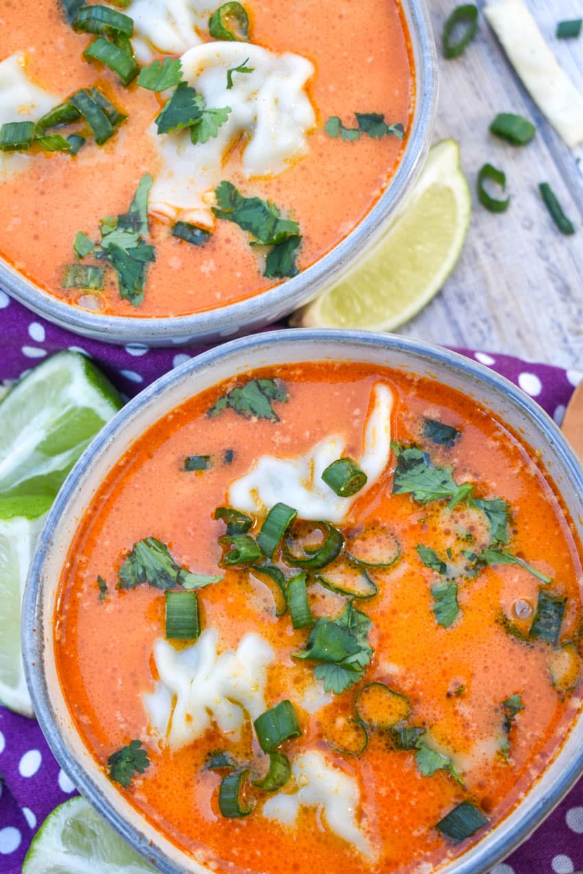coconut curry soup with wontons in two small gray bowls