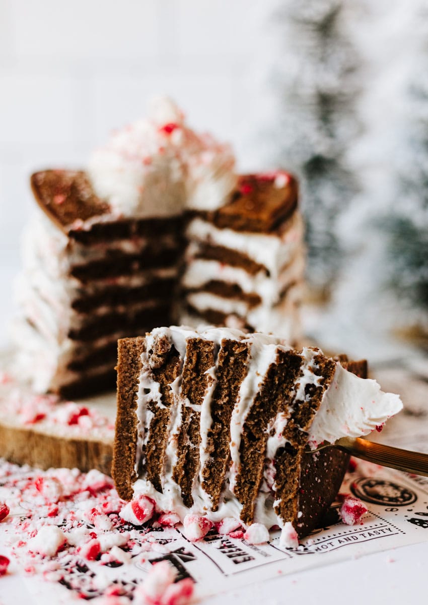 a stack of peppermint pancakes on a wooden cutting board surrounded by peppermint candy pieces