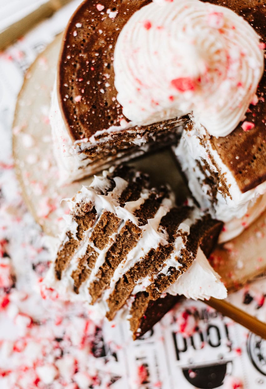 a stack of peppermint pancakes on a wooden cutting board surrounded by peppermint candy pieces