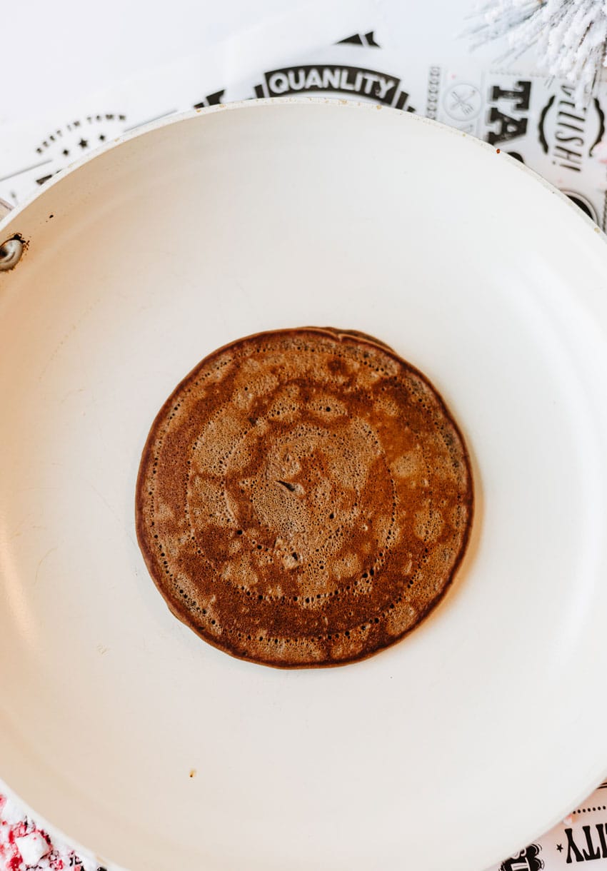 a homemade chocolate pancake with peppermint candy in a large white skillet