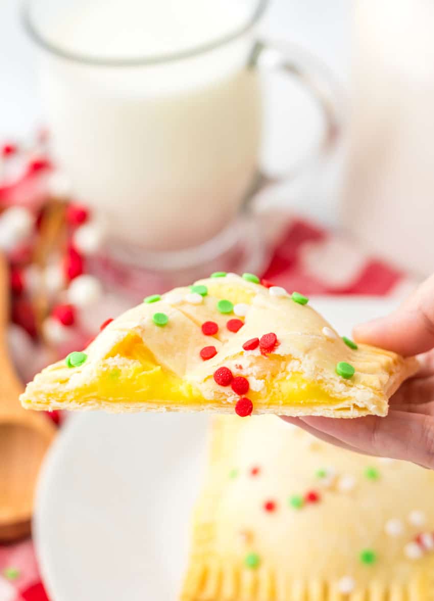 a hand holding up half of a homemade mcdonald's holiday pie to show the creamy pudding filled center