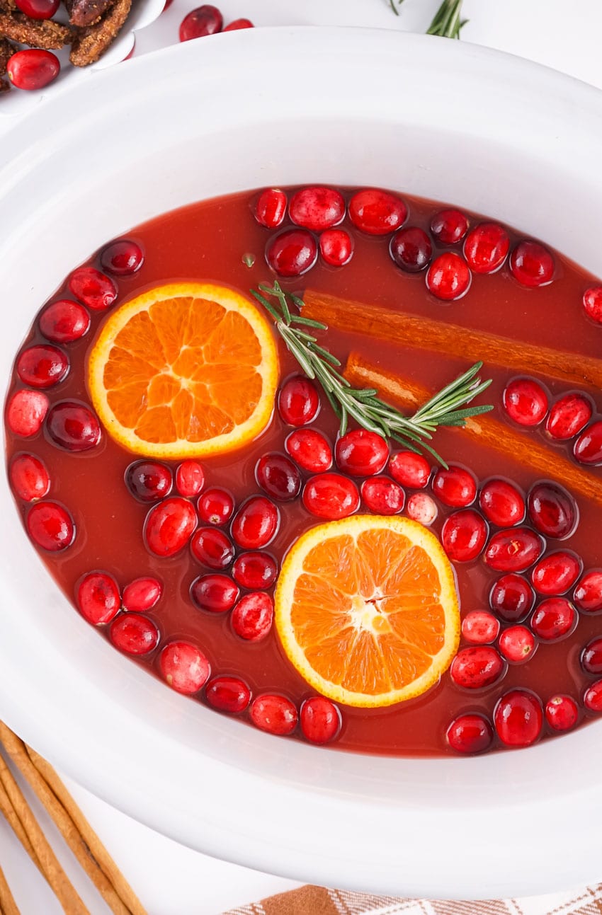 slow cooker hot christmas punch in a white crockpot