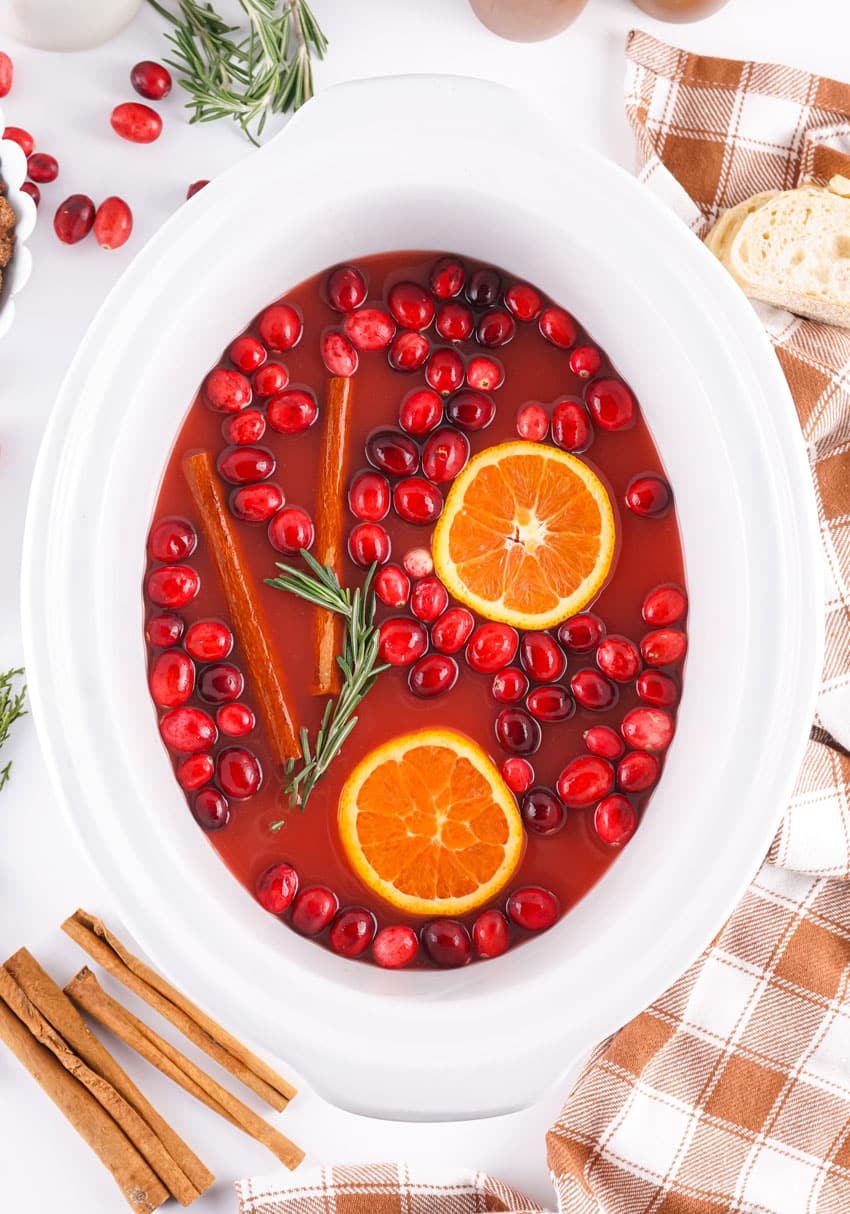slow cooker hot christmas punch in a white crockpot