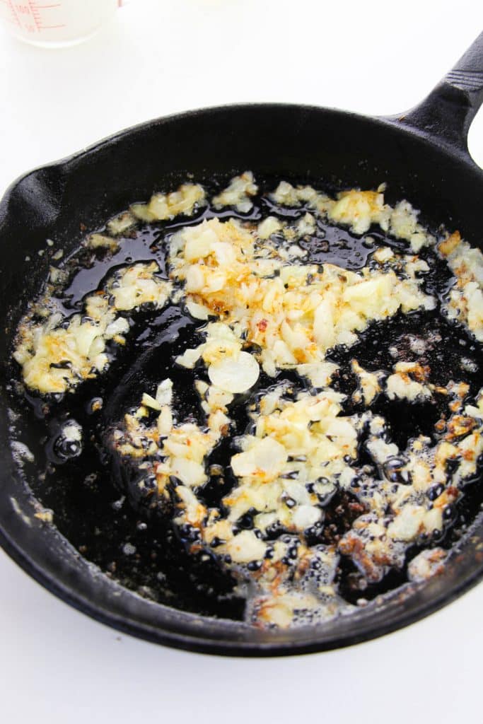 diced onions in butter in a cast iron skillet