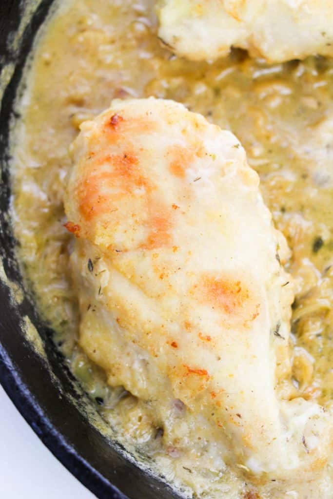 crispy chicken breast added to a skillet with onion gravy