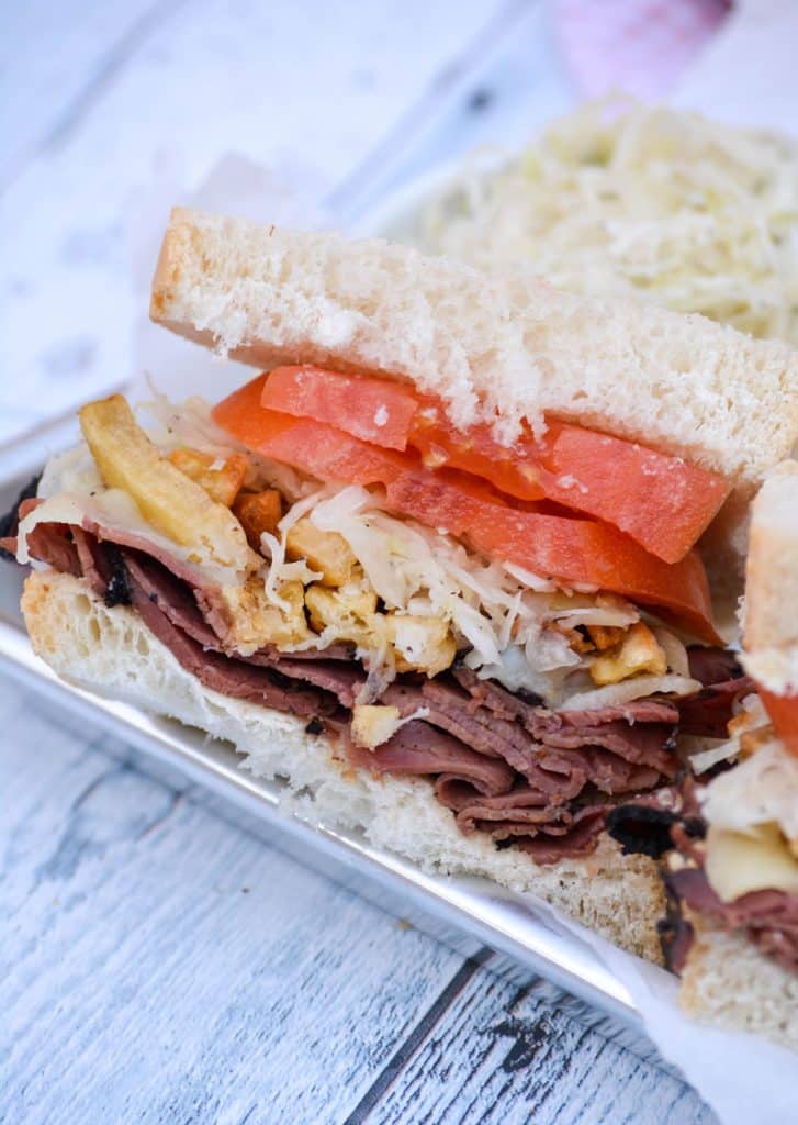 half of a primanti brothers copycat sandwich cut in half and shown on a metal serving tray