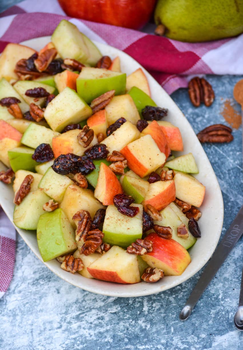 Fall Fruit Salad Fall fruit salad topped with raisins and ground cinnamon served in a shallow oval dish