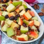 Fall fruit salad with dried cranberries and pecans served in a shallow oval shaped bowl