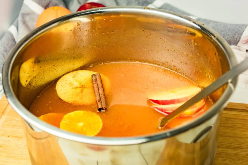 spiced cider with pumpkin shown in a silver bowl with a metal ladle