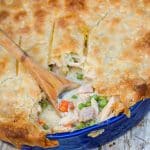 a wooden spoon scooping out the creamy center of shortcut chicken pot pie