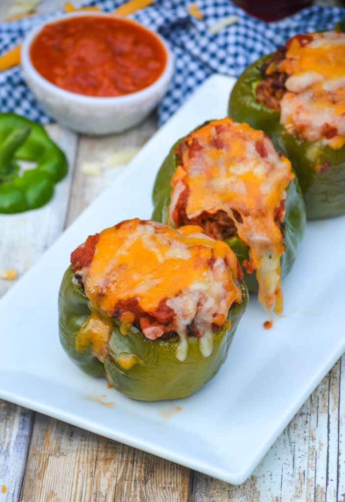 air fryer stuffed peppers arranged in a single line on a narrow white platter