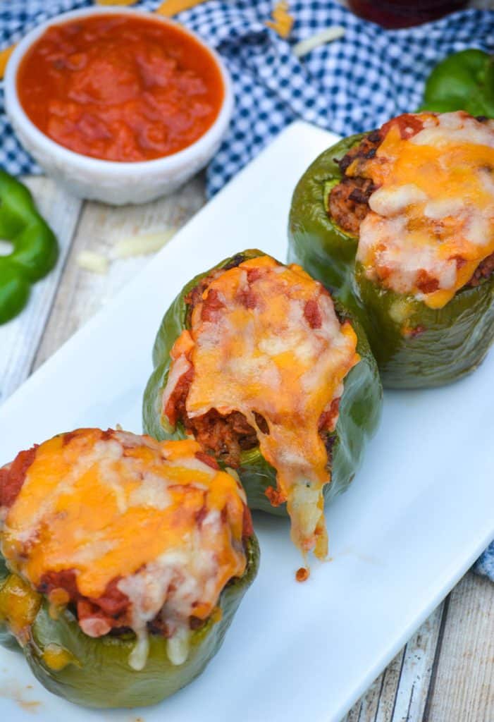 air fryer stuffed peppers arranged in a single line on a narrow white platter