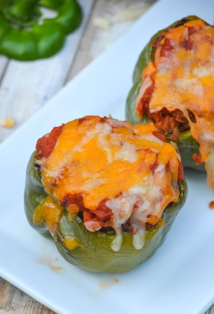 air fryer stuffed peppers arranged in a single line on a narrow white platter